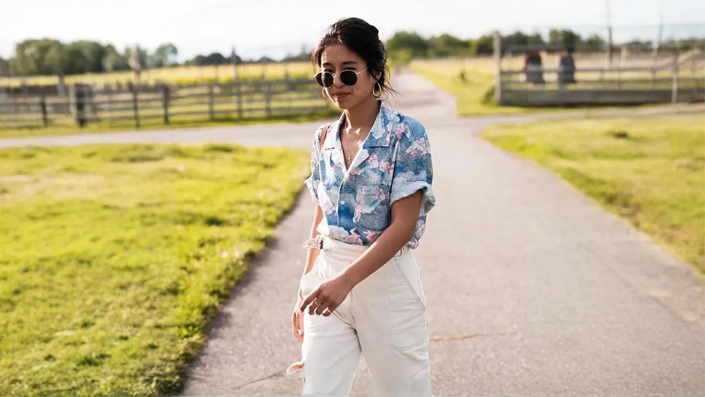 A woman rocking a folded cuff Hawaiian shirt paired with khaki pants for a bold, laid back look